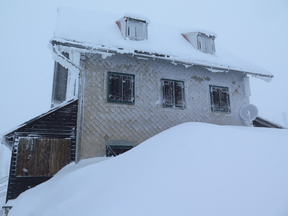 1 das altehrwuerdige Rachelschutzhaus von meterhohen Schneewehen umzingelt